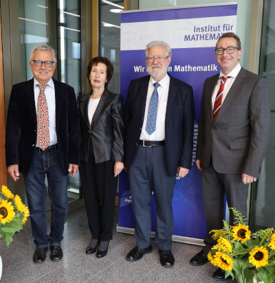 Two award winners with laudator G. Kaiser and organizer H.-S. Siller.